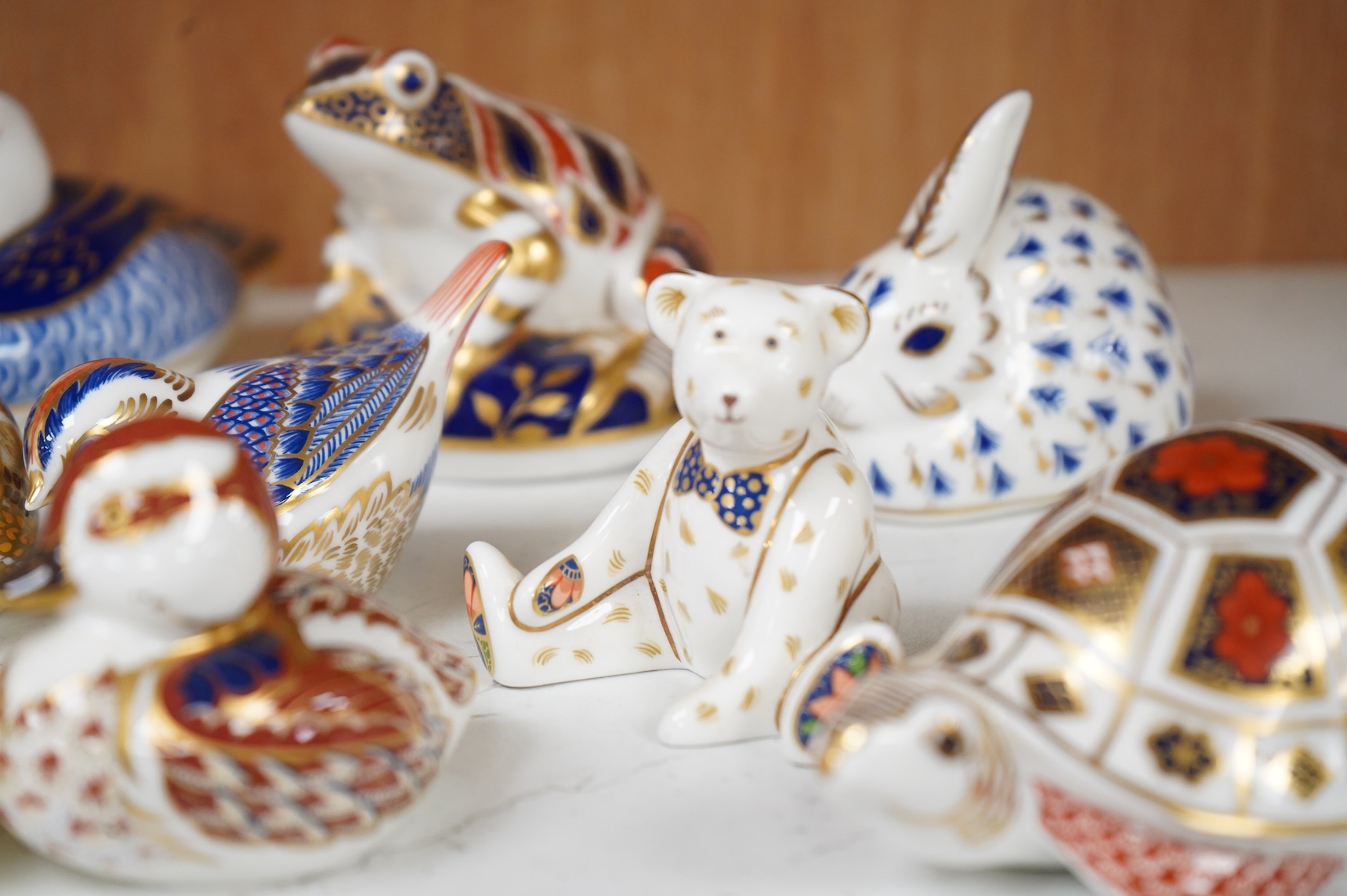 A collection of Royal Crown Derby Imari pattern paperweights, to include penguin and badger, together with three Doulton flambé animals, largest 19cm wide